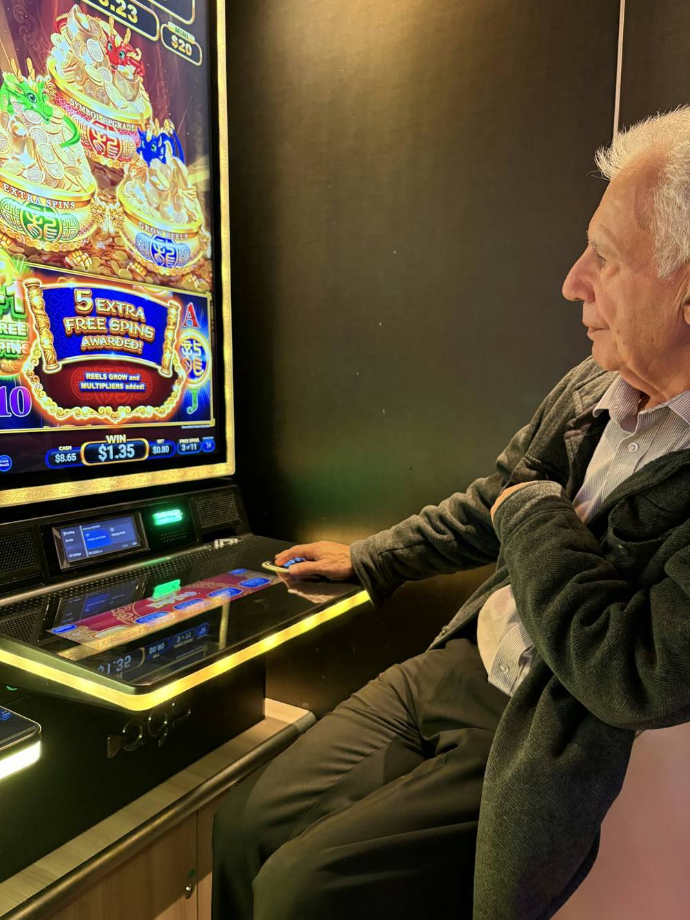 Older man sitting at a slot machine