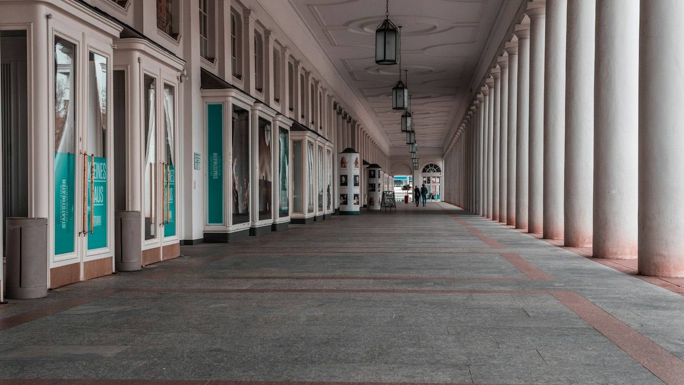 Long colonnade with doors and posters of the Staatstheater Wiesbaden